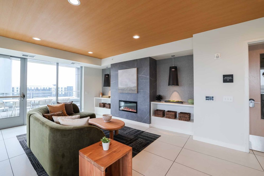 A modern living room with a green couch and a wooden coffee table.