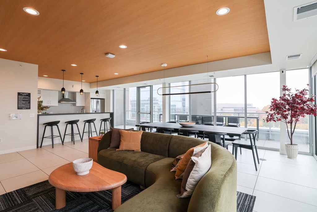 A modern living room with a green couch and a wooden table.