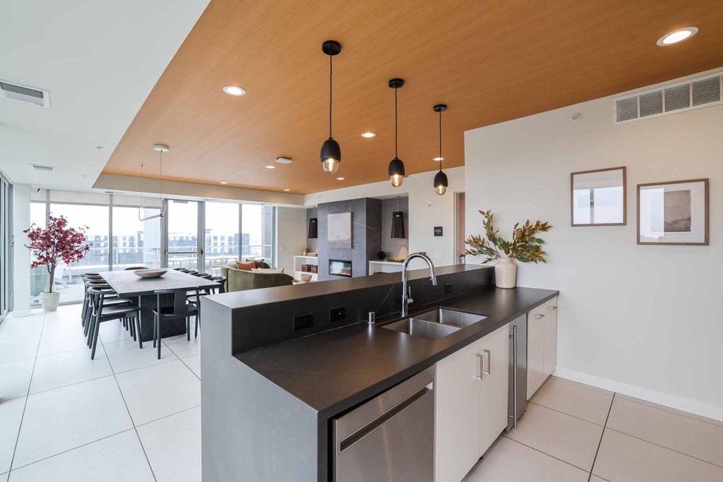 A modern kitchen with a large island and pendant lights.