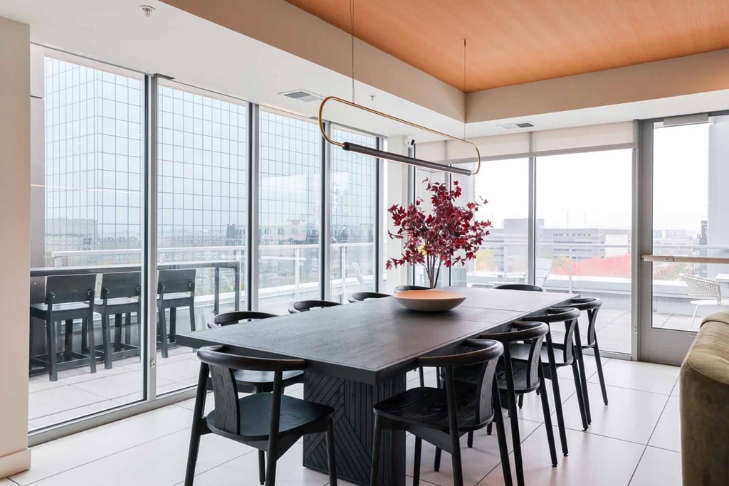 A modern dining room with a long table and chairs.