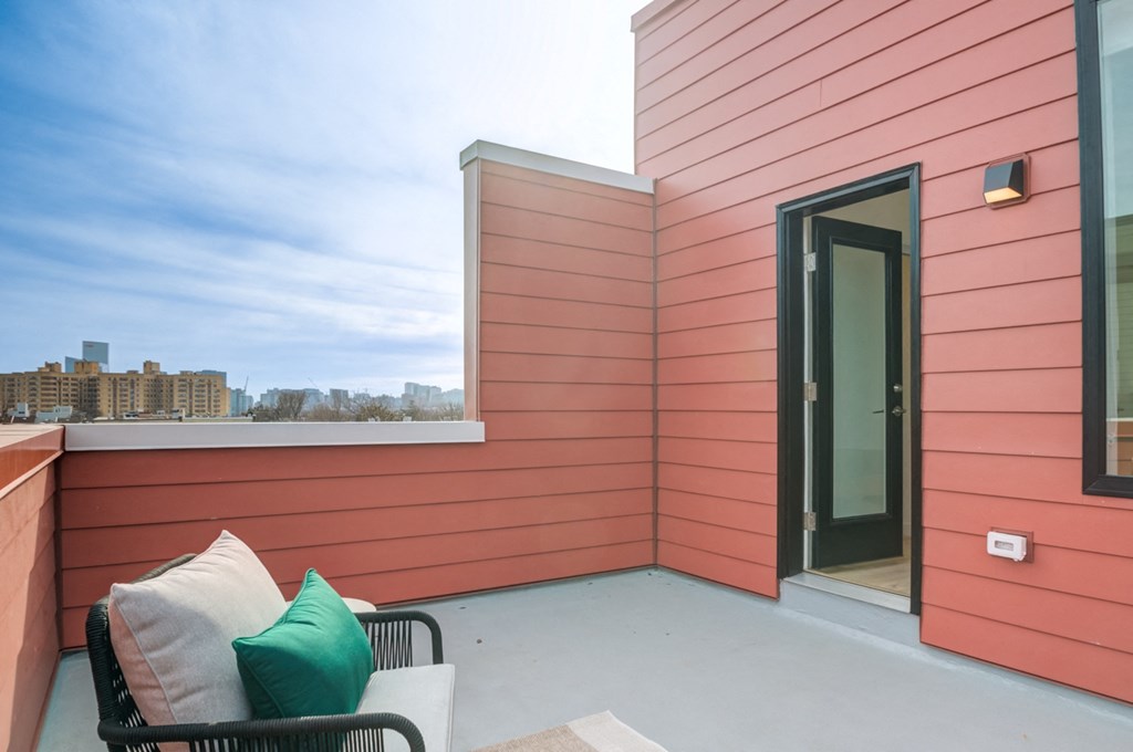 a balcony with a couch and a chair and a door
