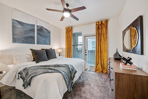a bedroom with a large bed and a ceiling fan