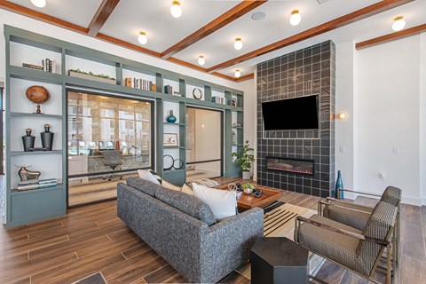 A living room with a grey couch and a fireplace.