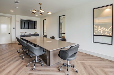 A conference room with a long table and chairs.