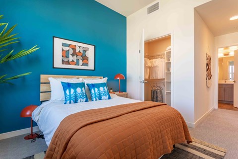 A bedroom with a bed and a blue wall.