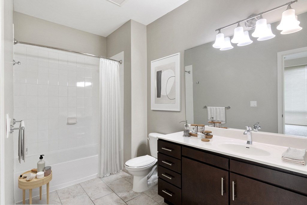 bathroom with dark wood vanity and tub shower