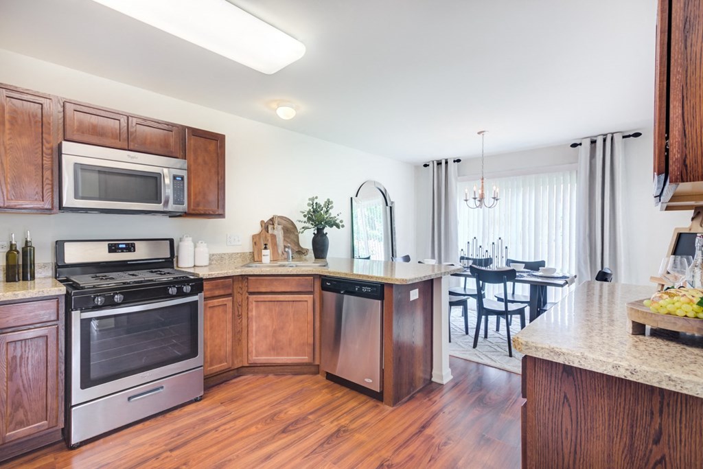 a kitchen with wooden cabinets and stainless steel appliances