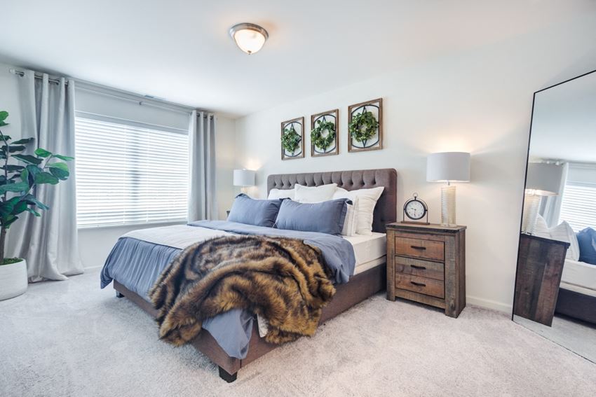 a bedroom with a bed and a dresser with a mirror - Photo Gallery