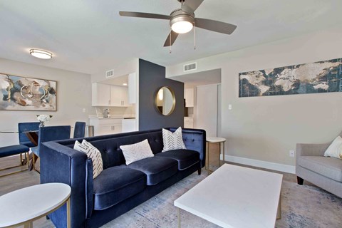 a living room with a blue couch and a white table