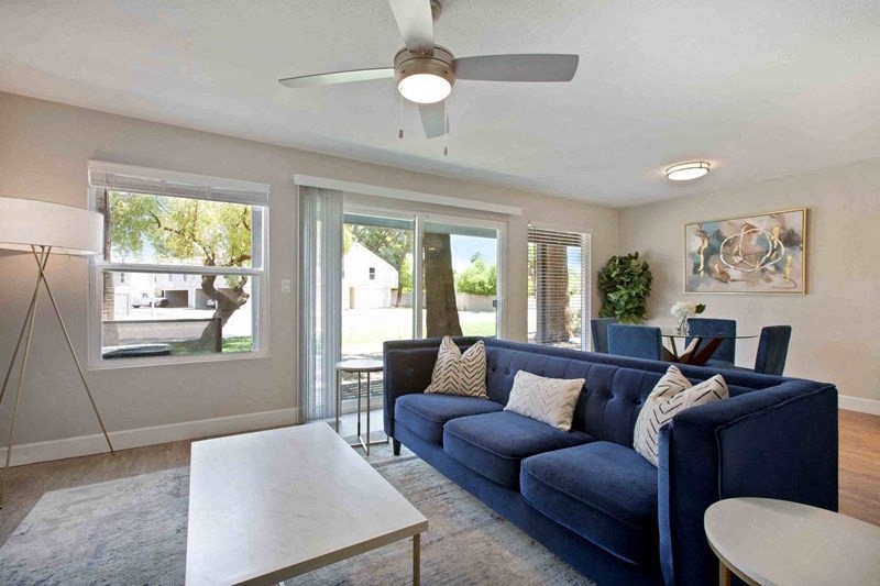 A living room with a blue couch and a white coffee table.