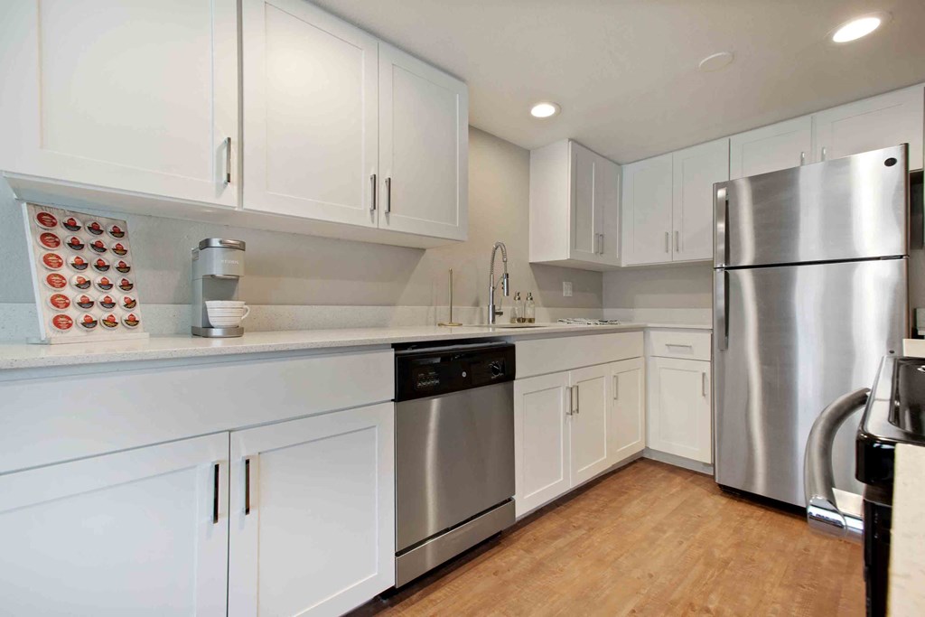 a white kitchen with stainless steel appliances and white cabinets