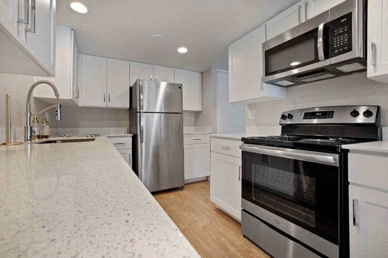 A modern kitchen with stainless steel appliances and white cabinets.