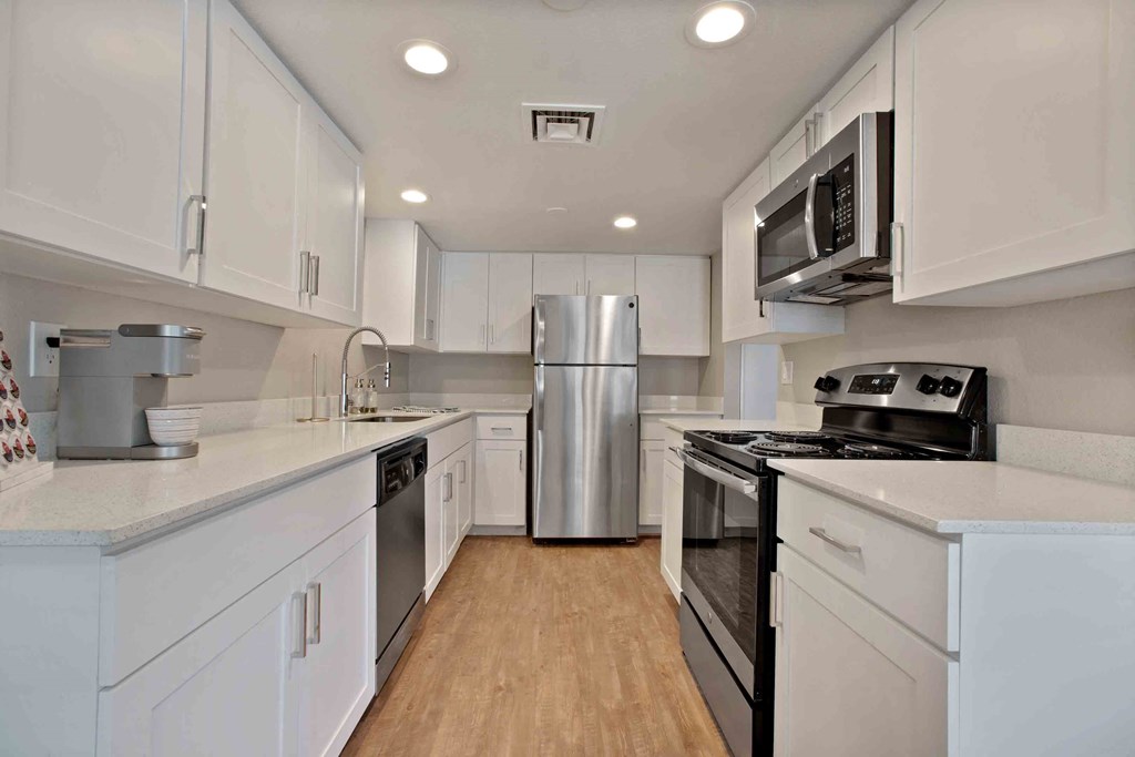 a kitchen with white cabinets and a stainless steel refrigerator
