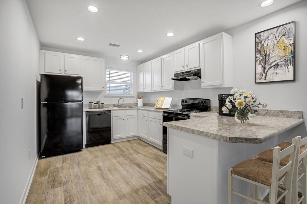 Spacious kitchen with efficient appliances and abundant cabinet space at The Marley at Trout River in Jacksonville, Florida. kitchen with white cabinets and a black refrigerator