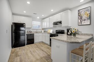 The Marley at Trout River Apartments in Jacksonville, FL 32218 a kitchen with white cabinets and a black refrigerator