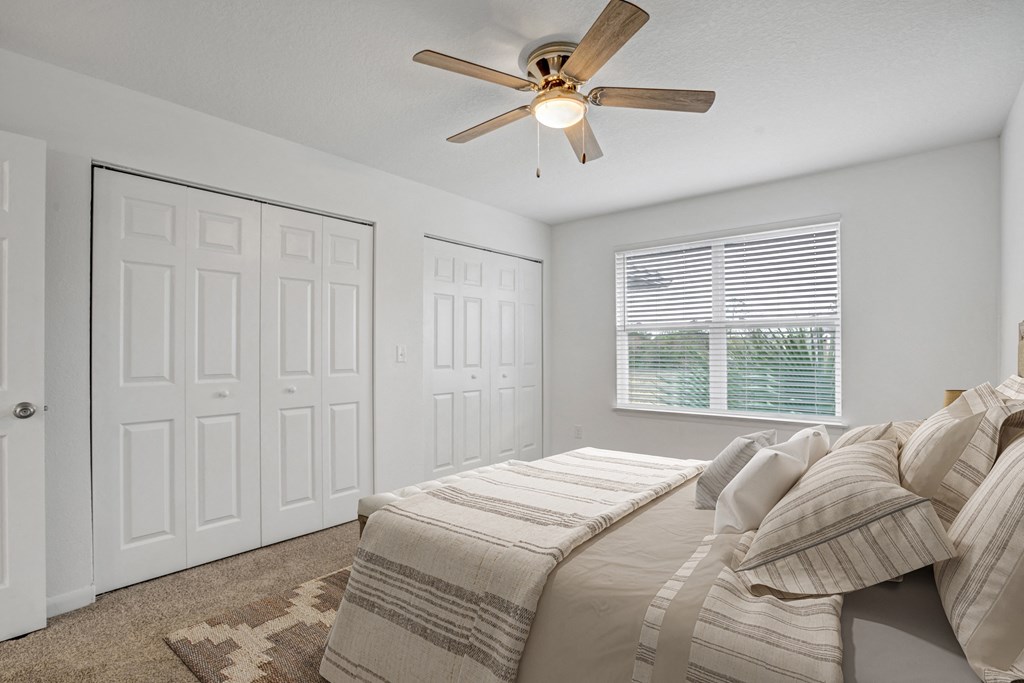 The Marley at Trout River Apartments in Jacksonville, FL 32218 a bedroom with a bed and a ceiling fan