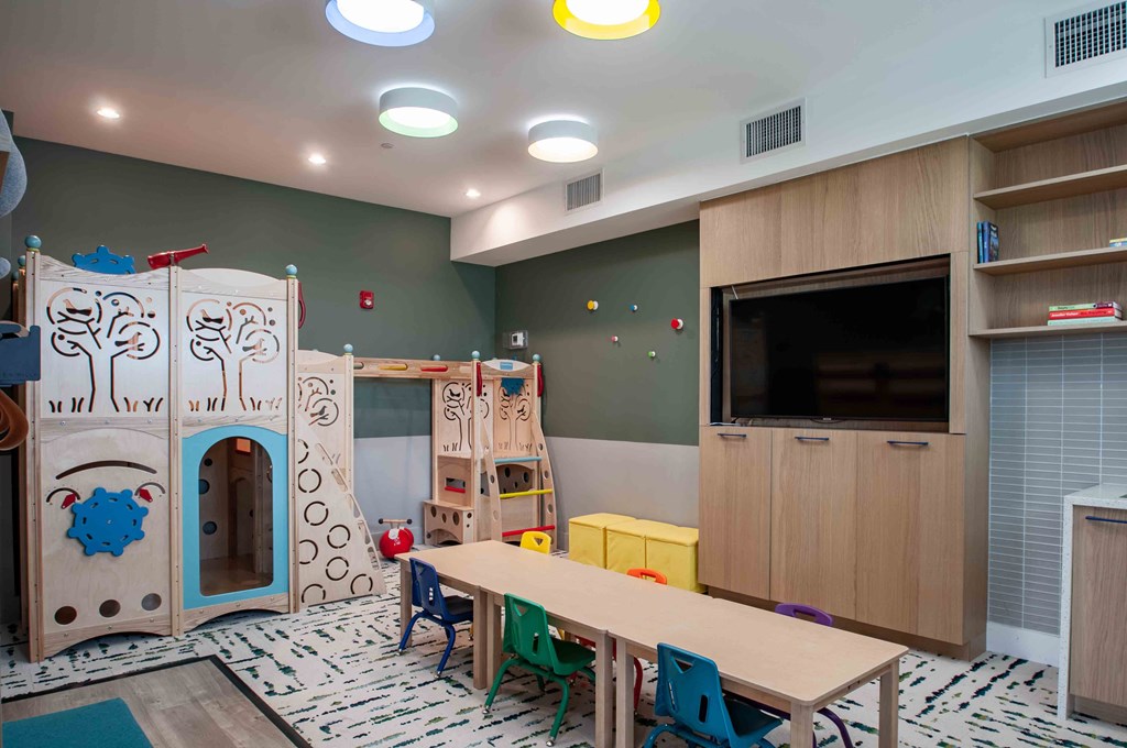 a play room with a table and a playset