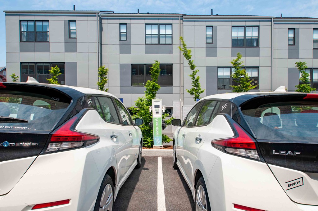 two cars parked in a parking lot in front of a building