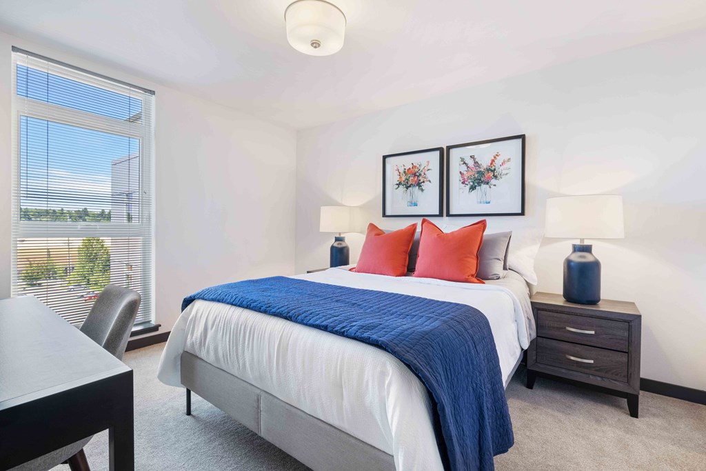 Apartments In Greenwood, WA For Rent - The Morrow - Spacious Bedroom With Plush Carpet Flooring, Floor-to-Ceiling Window, And Ceiling Light