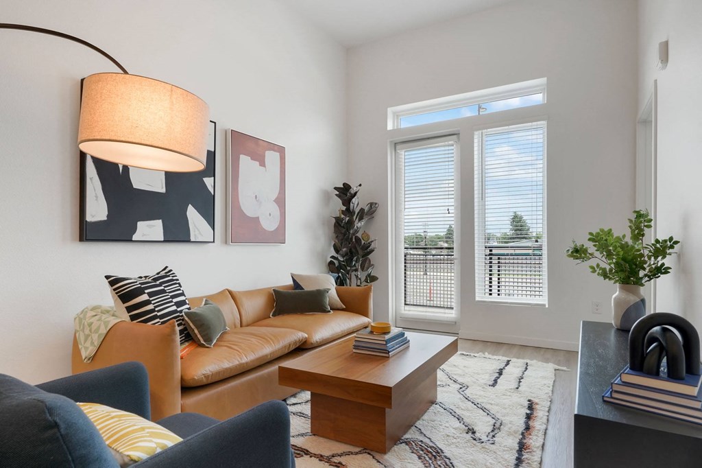 2-BR Apartments in Wheat Ridge, CO - Parallel - Living Room with Couch, Chair, Area Rug, Coffee Table, Large Window, Luxury Plank Flooring.