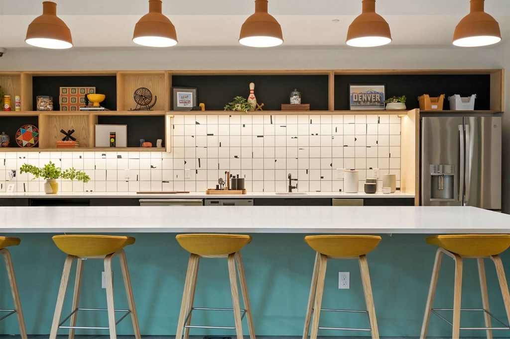a kitchen with a white counter top and yellow and blue stools