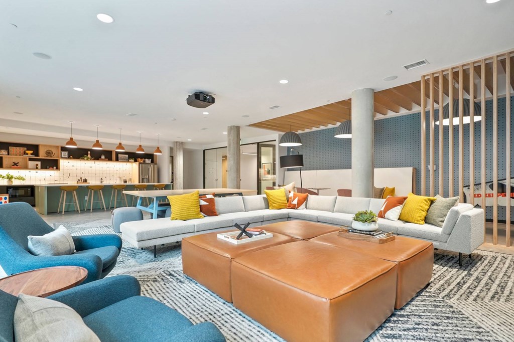 Apartments For Rent In Wheat Ridge, CO - The Parallel - Clubroom With Chef’s Kitchen, TV Lounge, Game Area, Couches, Lounge Chairs, and Screen Projector