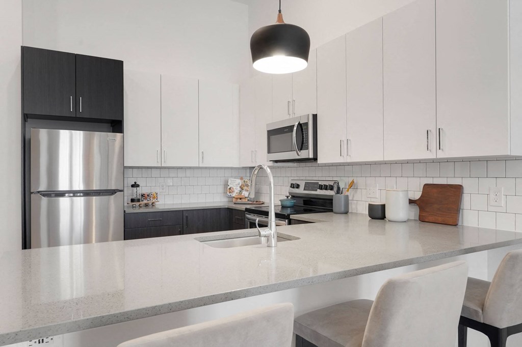 a kitchen with a counter top and a stainless steel refrigerator