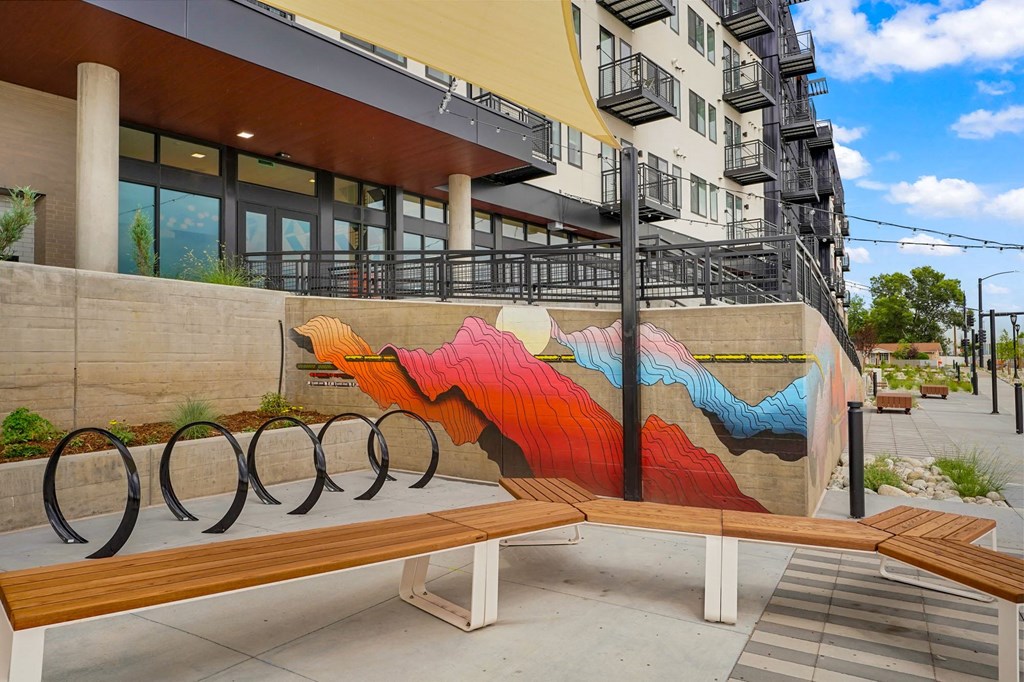 a bench with a mural on the side of a building