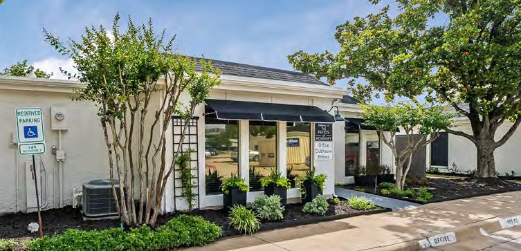 a small white building with trees in front of it