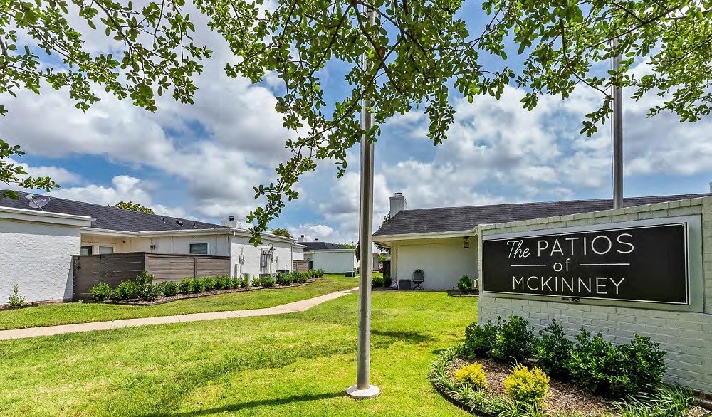 a grassy area with a sign that reads the patsies of mckinney