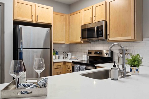a kitchen with a sink and refrigerator and wooden cabinets