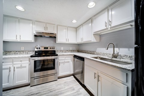a kitchen with white cabinets and stainless steel appliances