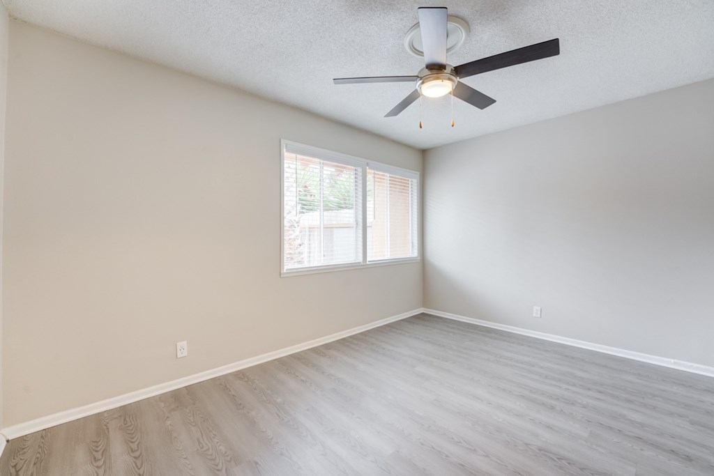 A room with a ceiling fan and a window.