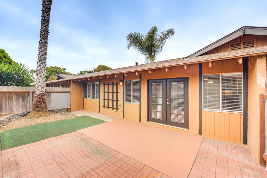 A building with a brown and tan exterior has a green lawn in front.