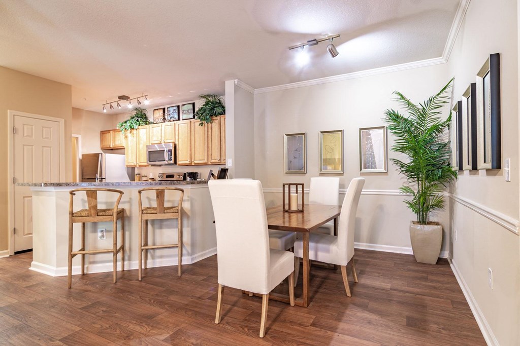 Apartments in Opelika for Rent – The Crossings of Opelika - a dining area with a table and chairs and a kitchen in the background