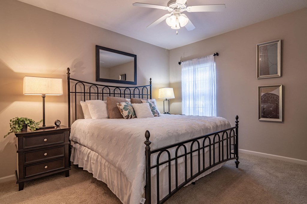 Pet-Friendly Apartments in Opelika, AL – The Crossings of Opelika - a bedroom with a bed and a ceiling fan and