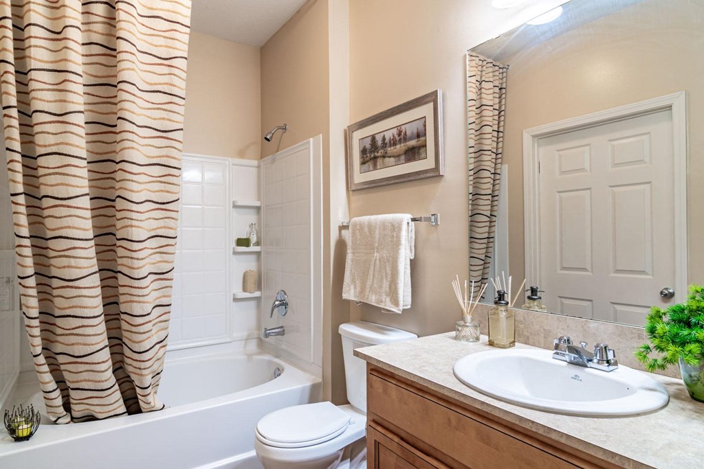 Opelika, AL Apartments – The Crossings of Opelika - a bathroom with a white toilet next to a white bathtub