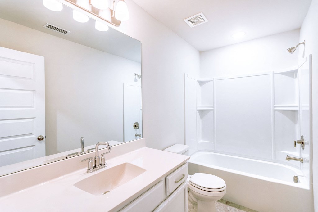 a bathroom with a white sink and toilet next to a white bathtub