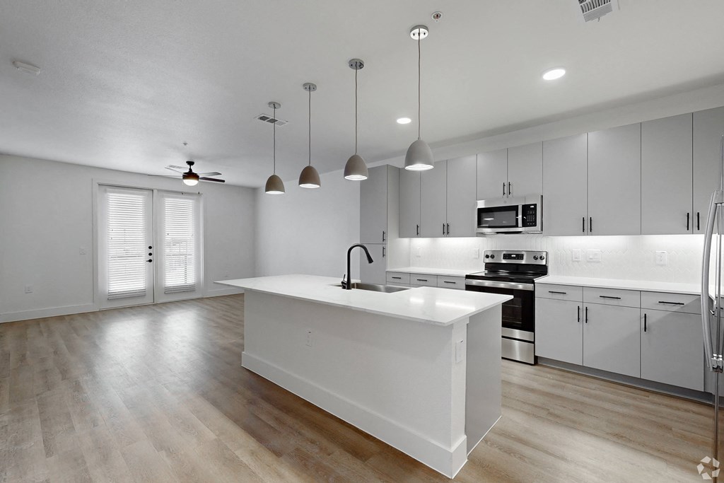 a large kitchen with white cabinets and a white counter top