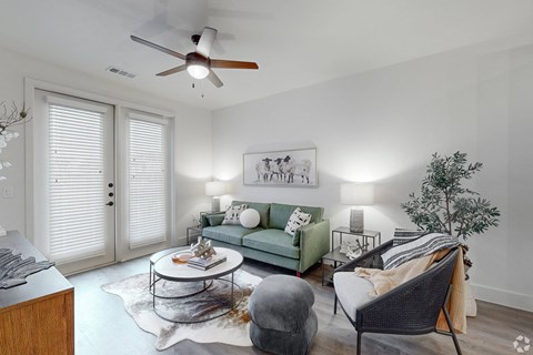 an open living room with a ceiling fan and a green couch