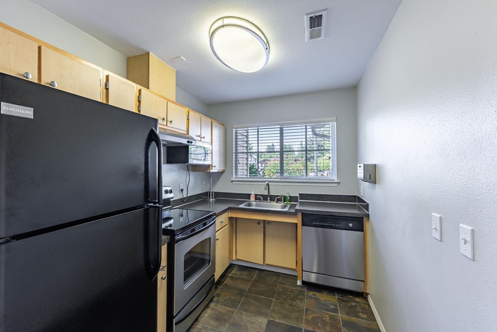 a kitchen with black appliances and a window