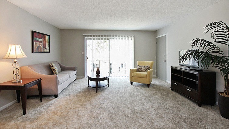 Living room with large sliding glass doors bringing in plenty of natural light at pet-friendly Estuary apartments in Atlanta, GA 30341, near Chamblee and Brookhaven.