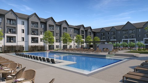 A large swimming pool surrounded by lounge chairs in front of apartment buildings.