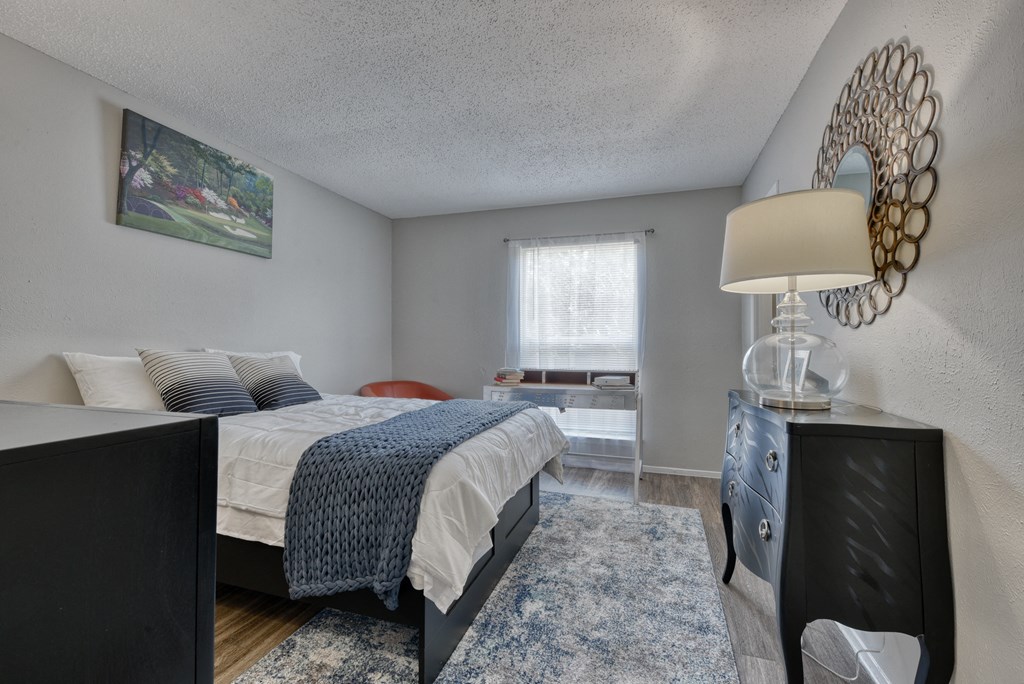 a bedroom with a bed and a dresser and a window