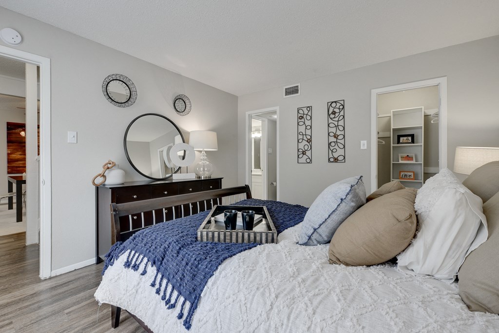 a bedroom with a bed with pillows and a blue blanket