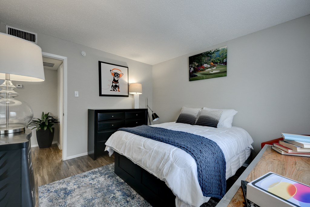 the view of a bedroom with a bed and a dresser and a window