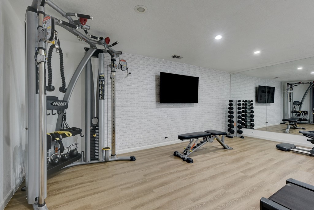 a home gym with weights and a tv on the wall