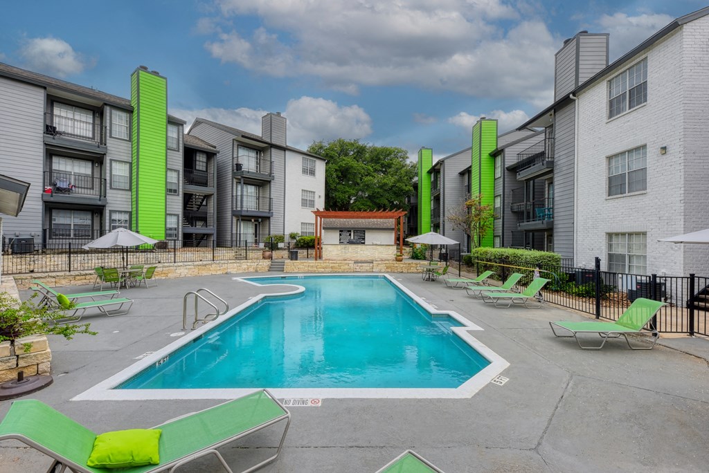 our apartments have a swimming pool and a patio with green chairs