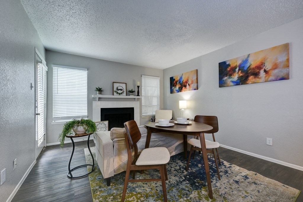 a living room with a table and chairs and a fireplace
