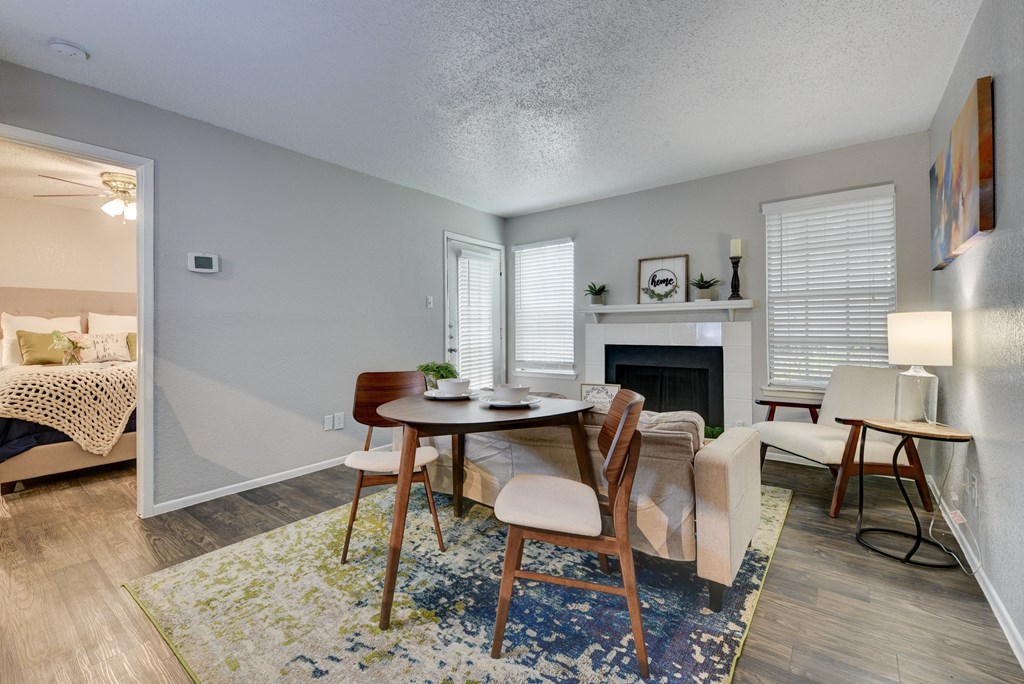a living room with a dining room table and a fireplace